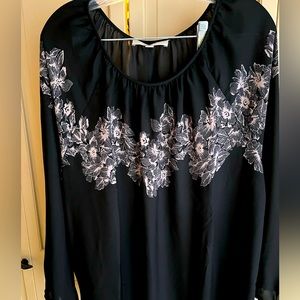 Black long sleeve blouse with beige flowers.